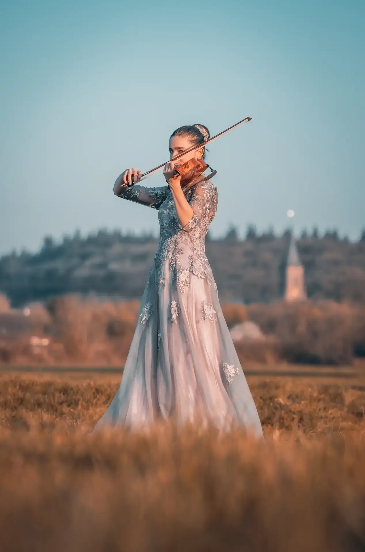 Violinistin in einem Kleid spielt im Freien